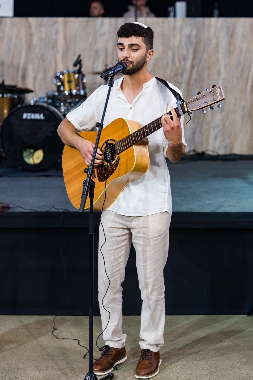Shaked singing and playing guitar on stage